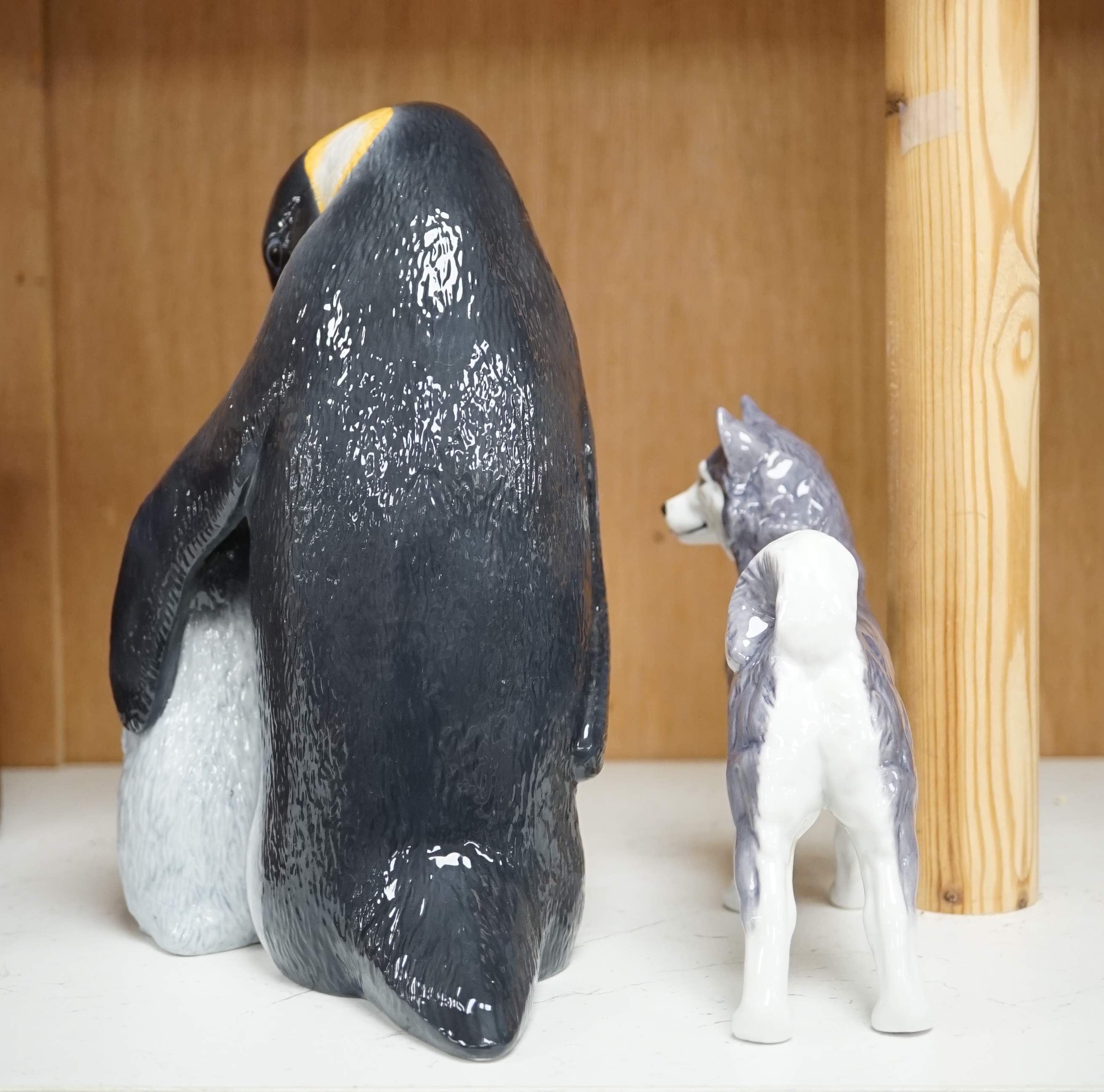 A Royal Copenhagen penguin group and a similar husky figure, 088 and 038, tallest 22cm. Condition - good